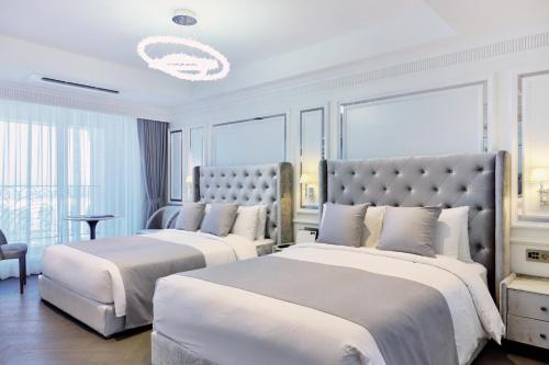 a bedroom with two beds and a large window at The Siena PRIMO in Seogwipo