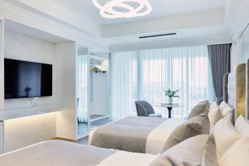a hotel room with two beds and a television at The Siena PRIMO in Seogwipo