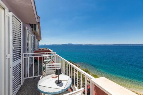 a balcony with a table and chairs and the ocean at Apartments and rooms by the sea Podgora, Makarska - 2616 in Podgora