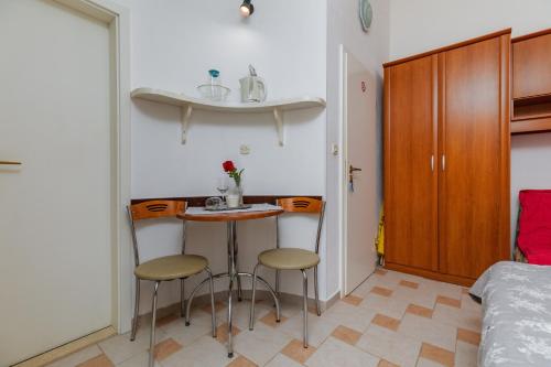 a small kitchen with two stools and a table in a room at Apartments and rooms by the sea Podgora, Makarska - 2616 in Podgora