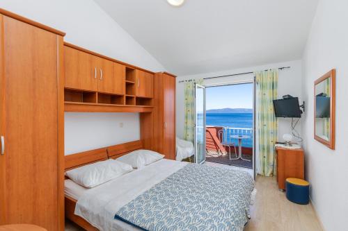 a bedroom with a bed and a view of the ocean at Apartments and rooms by the sea Podgora, Makarska - 2616 in Podgora