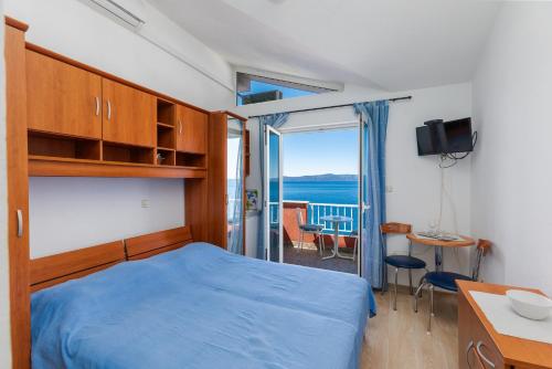 a bedroom with a bed and a view of the ocean at Apartments and rooms by the sea Podgora, Makarska - 2616 in Podgora