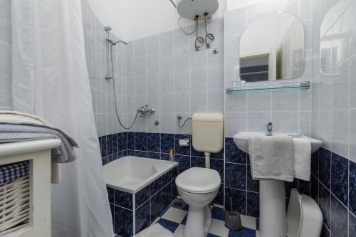 a blue tiled bathroom with a toilet and a sink at Apartments and rooms by the sea Podgora, Makarska - 2616 in Podgora