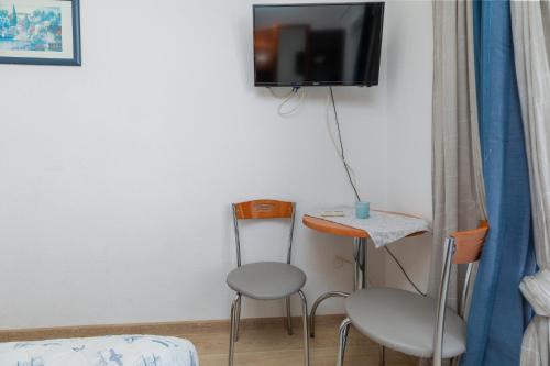 a room with two chairs and a table and a tv at Apartments and rooms by the sea Podgora, Makarska - 2616 in Podgora
