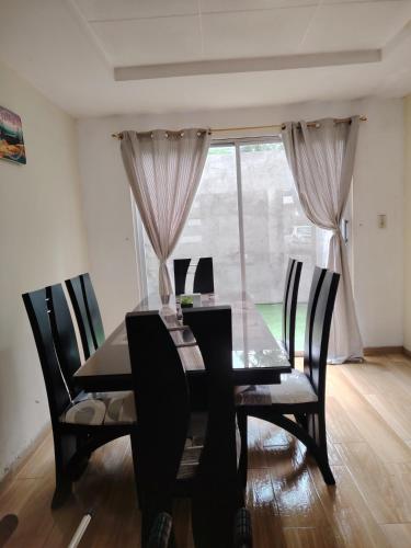 a dining room table with chairs and a window at Dulce Hogar 01 in Loja