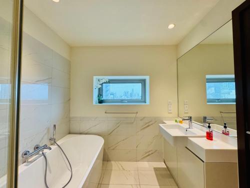 y baño con bañera, 2 lavabos y bañera. en Welcome to Your 5-Star Stay at Cinnamon Life Suite, en Colombo