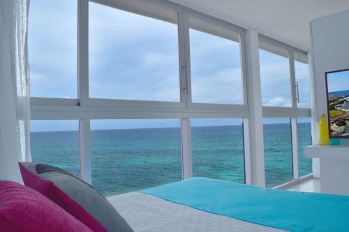 a bedroom with a view of the ocean through a window at Mia Reef Isla Mujeres - All Inclusive Resort in Isla Mujeres