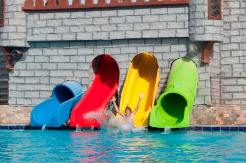 two children playing in the water in an outdoor swimming pool at Elite Residence Aqua Park in Ain Sokhna