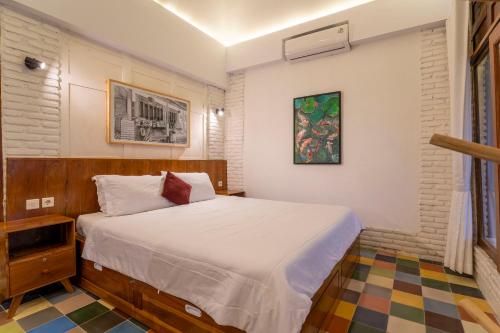 a bedroom with a bed and a painting on the wall at Villa Sare - House with panorama rice field view in Yogyakarta