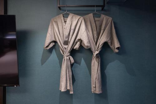 a group of robes hanging on a wall at 호텔 데일리 안산 in Ansan