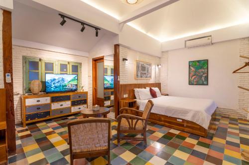 a bedroom with a bed and a tv in it at Villa Sare - House with panorama rice field view in Yogyakarta