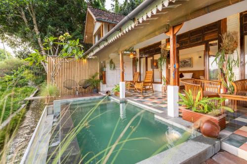 a house with a swimming pool in the yard at Villa Sare - House with panorama rice field view in Yogyakarta