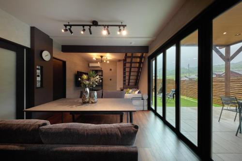 a dining room and living room with a table and chairs at Resoreat Shirahige in Takashima