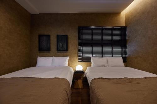 two beds sitting next to each other in a bedroom at Resoreat Shirahige in Takashima