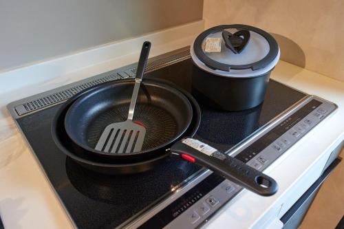 a frying pan on a stove with a spatula at Resoreat Shirahige in Takashima