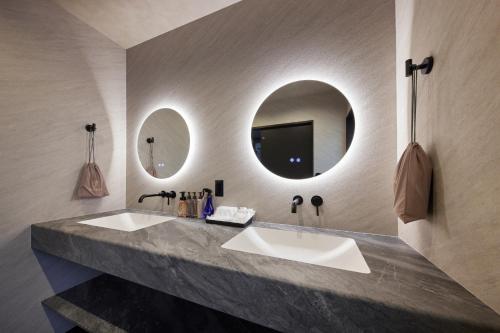 a bathroom with two sinks and two mirrors at Resoreat Shirahige in Takashima