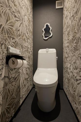 a bathroom with a toilet and a toilet paper dispenser at Resoreat Shirahige in Takashima