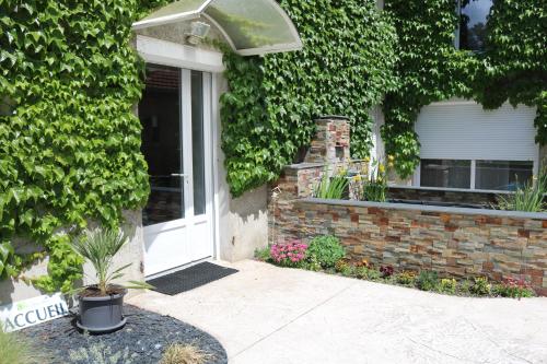 a front door of a house with a plant at Ch d'Hôte LE BON ABRI JURA in Marigny