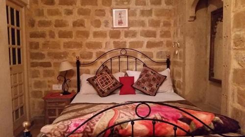 a bedroom with a bed with pillows on it at The Travellers Cup Fort Stay in Jaisalmer