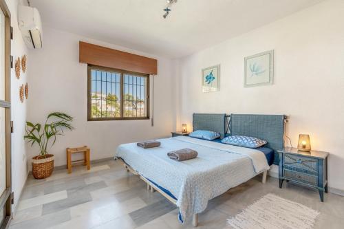 ein Schlafzimmer mit einem blauen Bett und einem Fenster in der Unterkunft Villa Andaluza in Almuñécar