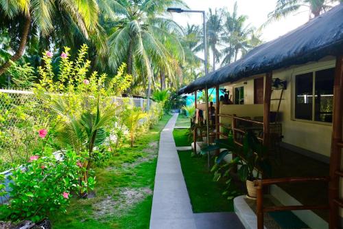 a house with a pathway leading to a garden at Skott's Comfy Lodge in Bantayan Island