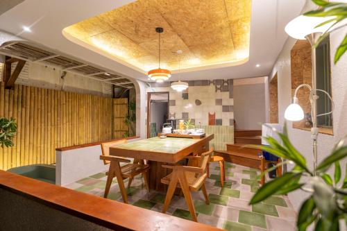 a dining room with a wooden table and chairs at Villa Sare - House with panorama rice field view in Yogyakarta