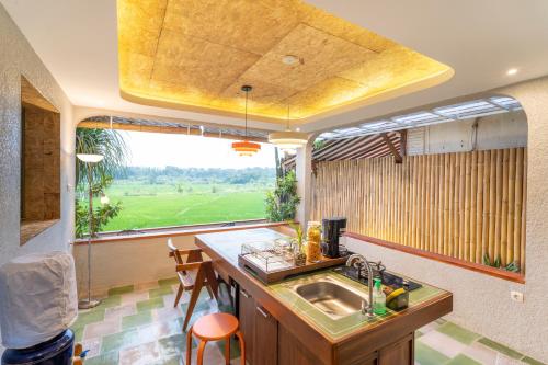 a kitchen with a sink and a large window at Villa Sare - House with panorama rice field view in Yogyakarta