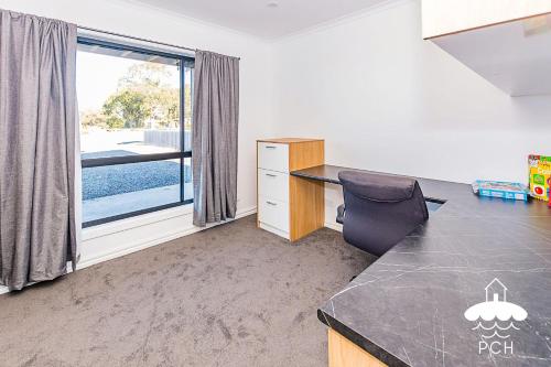 an office with a desk and a chair and a window at Fishermans Stay 