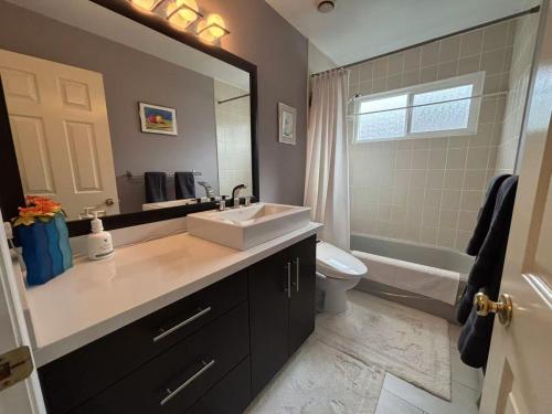 a bathroom with a sink and a toilet and a mirror at 温哥华列治文别墅民宿33 in Richmond