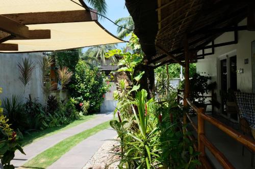 a walkway in a garden next to a house at Skott's Comfy Lodge in Bantayan Island