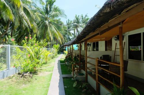 a house with a pathway next to a fence at Skott's Comfy Lodge in Bantayan Island