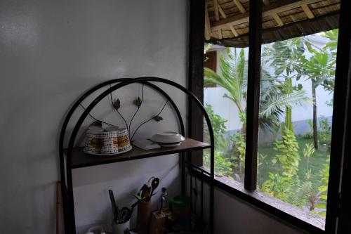 a shelf in a kitchen next to a window at Skott's Comfy Lodge in Bantayan Island