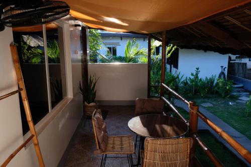 a balcony of a house with a table and chairs at Skott's Comfy Lodge in Bantayan Island
