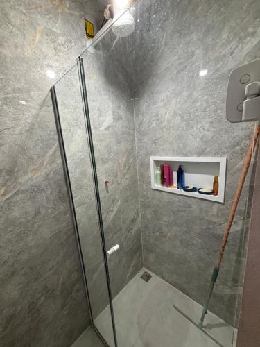 a bathroom with a shower with a glass shower stall at Casa aconchegante à 2 minutos da praia em Prainha de Mambucaba Paraty in Paraty