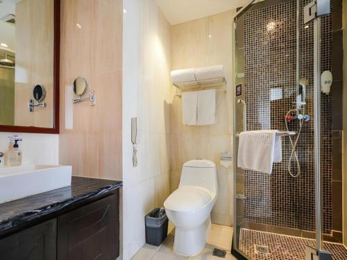 une salle de bain avec toilettes et douche en verre dans l'établissement Yitel Collection Beijing Capital Airport New International Exhibition, à Pékin