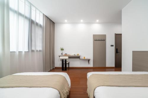 two beds in a room with white walls at Wangxian Mountain Retreat B&B-Wangxian Valley Scenic Area in Qiaotou