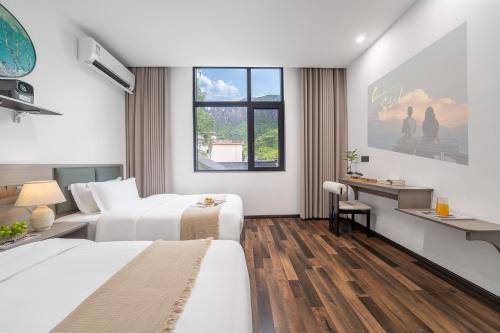 a hotel room with two beds and a desk at Wangxian Mountain Retreat B&B-Wangxian Valley Scenic Area in Qiaotou