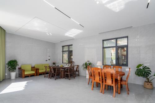 Un comedor con mesas y sillas y ventanas. en Wangxian Mountain Retreat B&B-Wangxian Valley Scenic Area, en Qiaotou