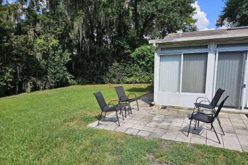 a group of chairs sitting on a patio in a yard at Rainey 5577 in Orange Park