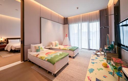 a bedroom with two beds and a flat screen tv at DoubleTree By Hilton Cangnan in Cangnan
