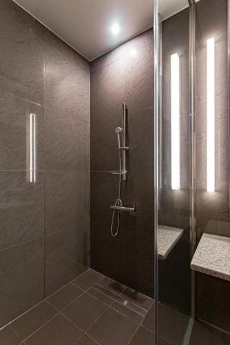 a bathroom with a shower with a glass door at Top Cloud Hotel Iksan in Iksan