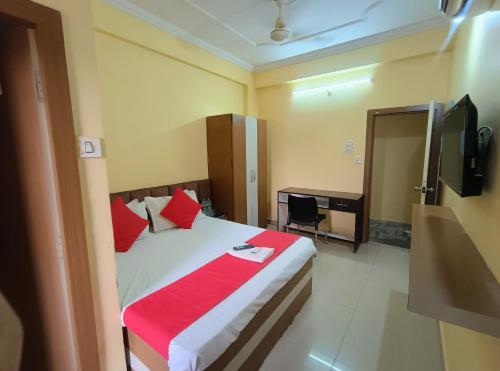 a bedroom with a bed with red pillows and a desk at Hotel K A Square in Bhopal