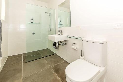 Un baño blanco con inodoro y lavabo. en Sunshine Hideaway, en Sandy Point