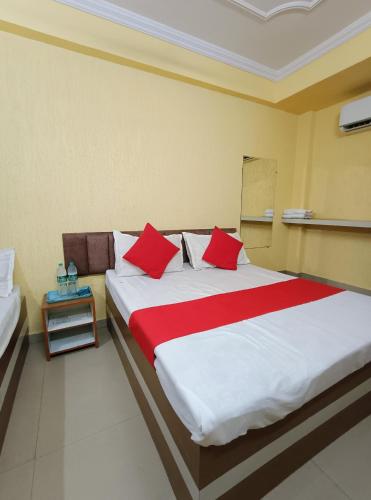 a bedroom with a large bed with red pillows at Hotel K A Square in Bhopal