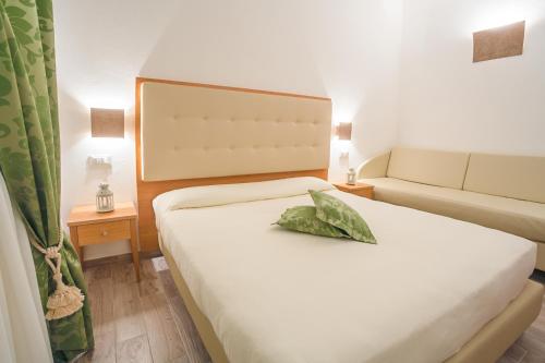 a hotel room with a bed and a couch at Hotel Il Buongustaio in Massa