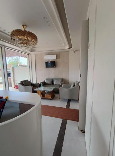 a living room with a couch and a chandelier at Hotel K A Square in Bhopal
