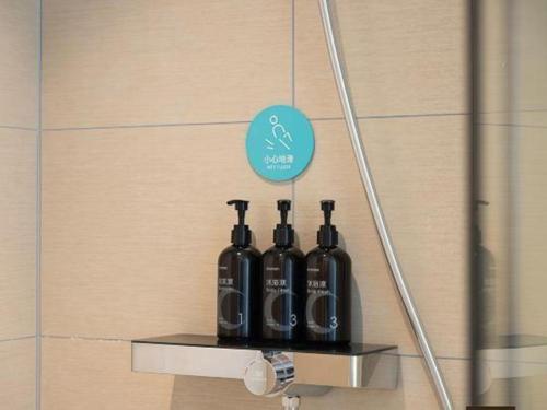 a group of bottles sitting on a shelf in a bathroom at City Comfort Inn Beihai RT-Mart High Speed Railway Station in Beihai