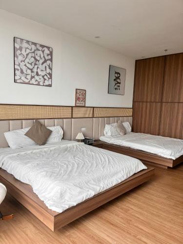 two beds in a hotel room with white sheets at Châu Giang Homestay, Nera Garden Huế in Thôn Văn Dương