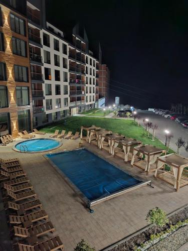 a swimming pool with tables and chairs and a building at ViS in Kopaonik