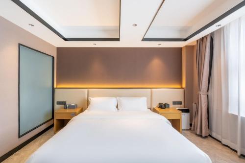 a bedroom with a large bed and a large window at Zhuhai Jinjunyao Hotel in Zhuhai